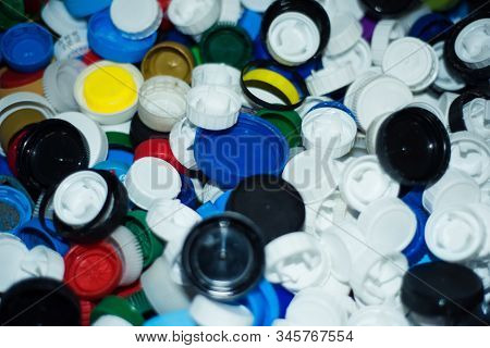 Waste Heap From Plastic Bottle Caps On Waste Sorting Station. Large Pile Of Colored Stoppers Destine