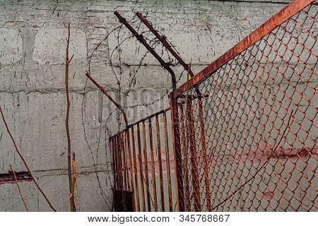 Rusty Barbed Wire On The Fence.