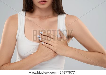 Clolse Up Of Incognito Caucasian Woman In White Shirt Posing Over Gray Isolated Background And Touch