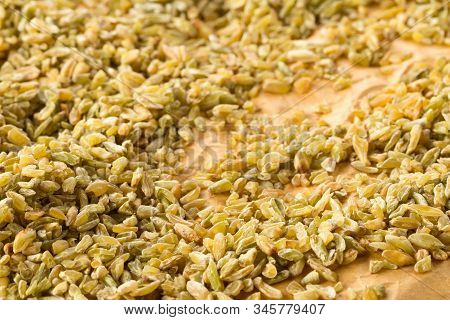 Heap Of Uncooked, Raw Freekeh Or Firik, Roasted Wheat Grain, On Brown Packing Paper Background With 