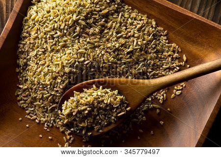Uncooked, Raw Freekeh Or Firik, Roasted Wheat Grain, On Wooden Plate With Wood Spoon On Brown Table 
