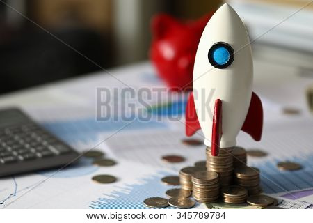 Close-up Of Rocket On Pile Of Golden Coins Symbolizing Company Profits Growth. Money Scattered All A