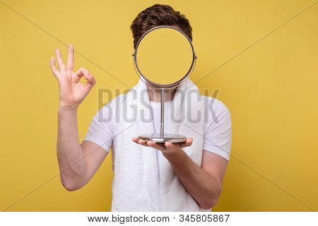 Anonym Man Looking At Himself In The Bathroom Mirror Shwoing Ok Sign.