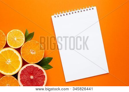 Notebook And Citruses Fruits On Orange Background, Fruit Flatlay, Summer Minimal Compositon With Gra