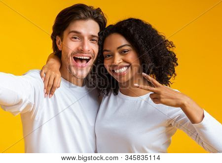 Cheerful Millennials Taking Selfie. Joyful Interracial Couple Capturing Self-portrait, Posing Togeth
