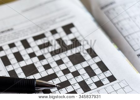Crossword Puzzle From Newspaper With A Pen To Fill In Answers