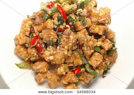 흰색 바탕에 요리에 칠리 소스와 함께 튀긴된 tempeh 조각