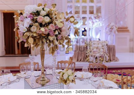 Beautiful Flowers Bouquet With Leaves On Pedestal Decorated Crystal Candlesticks. Festive Dining Tab