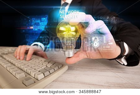 Businessman holding lightbulb with NETWORK SECURITY inscription, online security idea concept