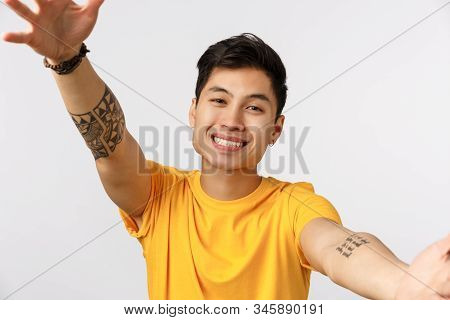 Close-up Shot Tender Charming Young Millennial Asian Guy In Yellow T-shirt, Spread Hands In Cuddle, 
