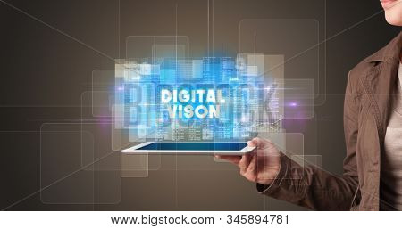 Young business person working on tablet and shows the inscription: DIGITAL VISON