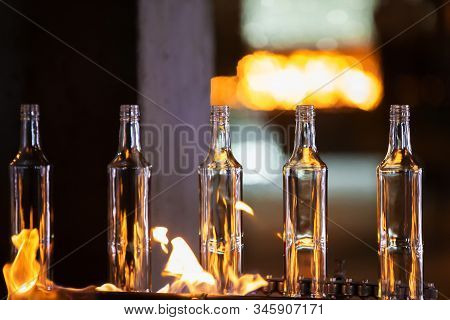 Glassworks. Glass Industry. Making Glass Bottles. Hot Bottle Blanks In Flame