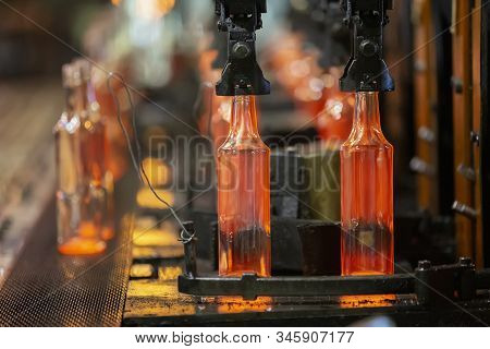 Glassworks. Glass Industry. The Process Of Making Glass Bottles.molten Hot Glass Containers On Conve