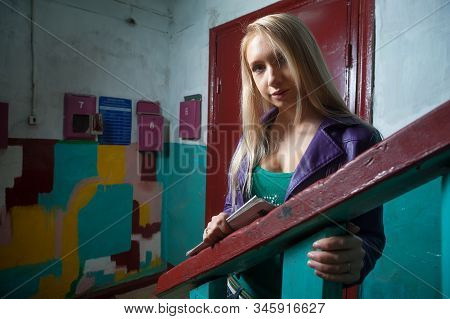 Young Attractive Woman Standing With Newspaper Near Postoffice Boxes