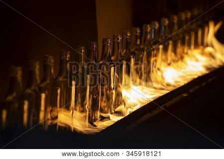 Glassworks. Glass Industry. Making Glass Bottles. Hot Bottle Blanks In Flame