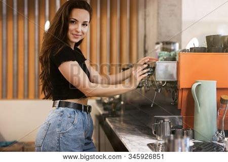 Beautiful Smiling Barista Woman Working Behind The Bar, Stands Near Professional Coffee Machine