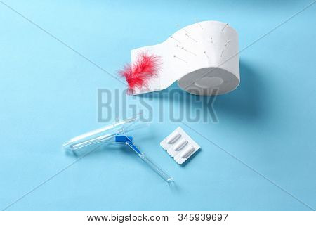 Anoscope, Suppositories And Toilet Paper With Red Feather On Light Blue Background, Flat Lay. Hemorr