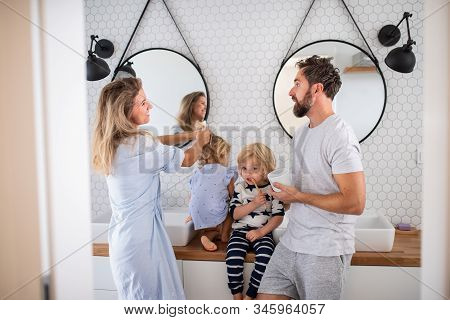 Young Family With Two Small Children Indoors In Bathroom, Talking.
