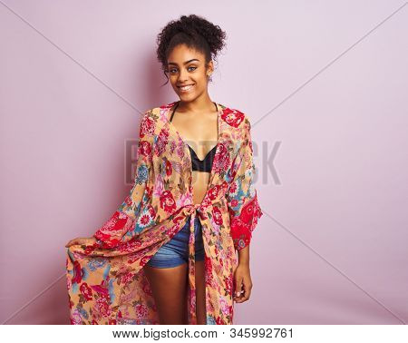 Young beautiful african american woman on vacation standing wearing bikini and colorful caftan