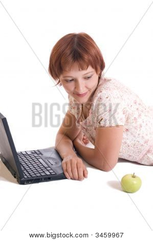 La bella ragazza romantica tra un Computer e una mela.