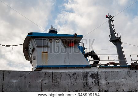 Older Boat In The Historical Port. Detail Of The Pilothouse. Seagull Sitting On The Top Of It. Cloud