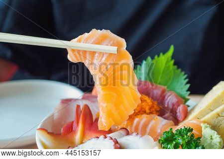Salmon Slice In Chopsticks, Eating Sashimi Rice Bowl Chirashi Don Japanese Food