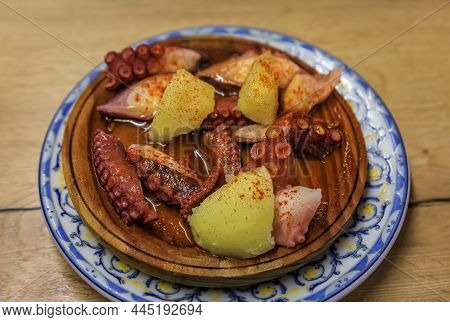 Traditional Basque Pintxos Octopus With Potatoes And Paprika In Olive Oil On A Wooden Platter In A B