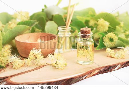 Linden Tree Blossom Esential Oil Glass Bottle Herbal Tincture Close-up, Fresh Green Lime Leaves. 
Bo