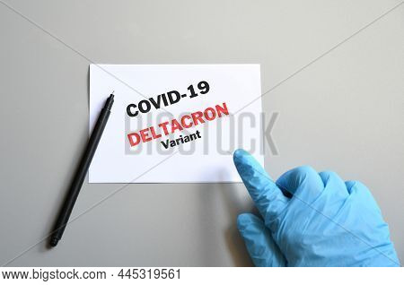 Doctor's Hand In Blue Glove With White Paper And Text Deltacron Variant. Concept Of Medical Variety 