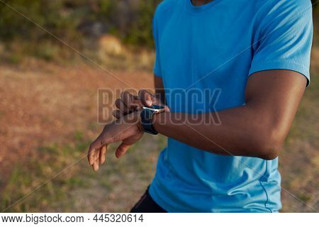 Close Up Of Black Young Adult Male Checking His Time Of His Run On His Watch. Outdoors, Training In 