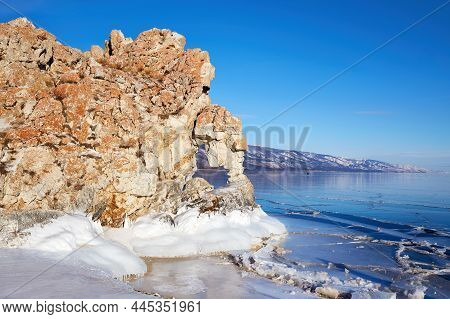 Frozen Lake Baikal, Transparent Ice. The Heart-shaped Arch In The Tsagan-khushun Rock Or The Window 