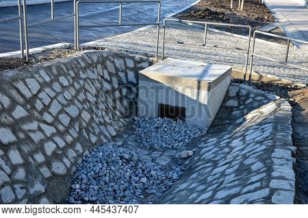 Sewer Gutter Paved With Granite Stone And Dikes Drains Rainwater By Ditch At The Highway Into The Re
