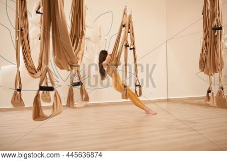 Fit Longh Haired Womanrelaxing On Fly Yoga Hammock At Sport Studio
