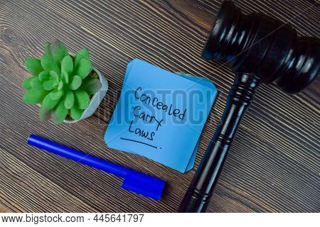Concealed Carry Laws Write On Sticky Notes Isolated On Wooden Table.