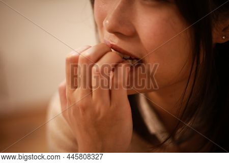 Image Of A Woman Biting Her Nails