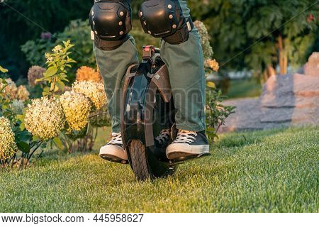 Rider's Legs In Protective Gear On An Electric Unicycle (euc). Driving Around The City On An Electri