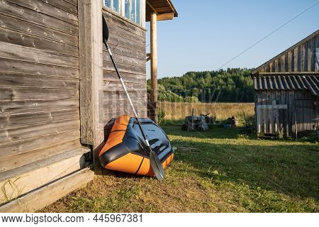 Packraft Stands On Her Side Leaning Against A Village House And Dries, Against The Backdrop Of A Won