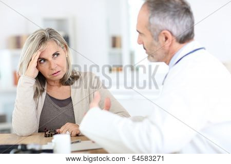 Doctor giving medicine to senior woman for arthritis pain