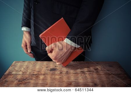 Man With Book At Desk