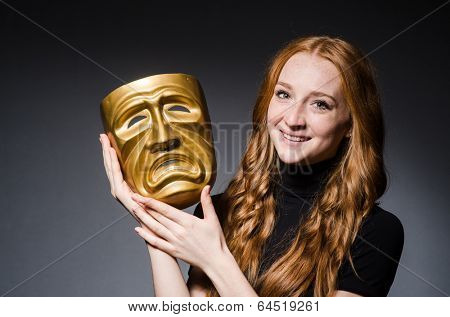 Redhead woman iwith mask in hypocrisy consept against grey background