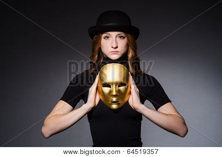 Redhead woman in hat  iwith mask in hypocrisy consept against grey background