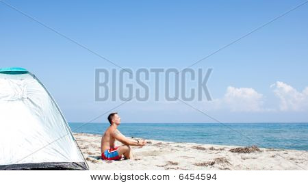 Man Meditating On Beach