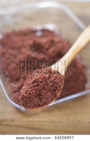 Sumak in a wooden spoon. Selective focus on the spice