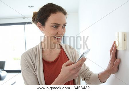Woman programming temperature inside home