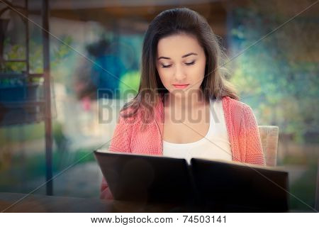 Young Woman Choosing from a Restaurant Menu