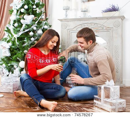 Young Happy Smiling Couple By The Cristmas Tree