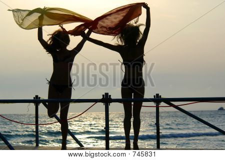 Silhuetas de duas meninas dançando com lenços