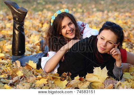 Happy Girl Relaxing On Yellow Autumn Leaves
