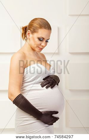 Young pregnant woman in fashionable dress