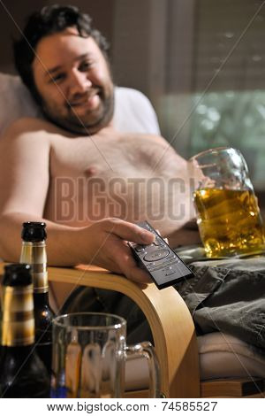 TV addicted man  sitting in chair with a beer glass and remote control